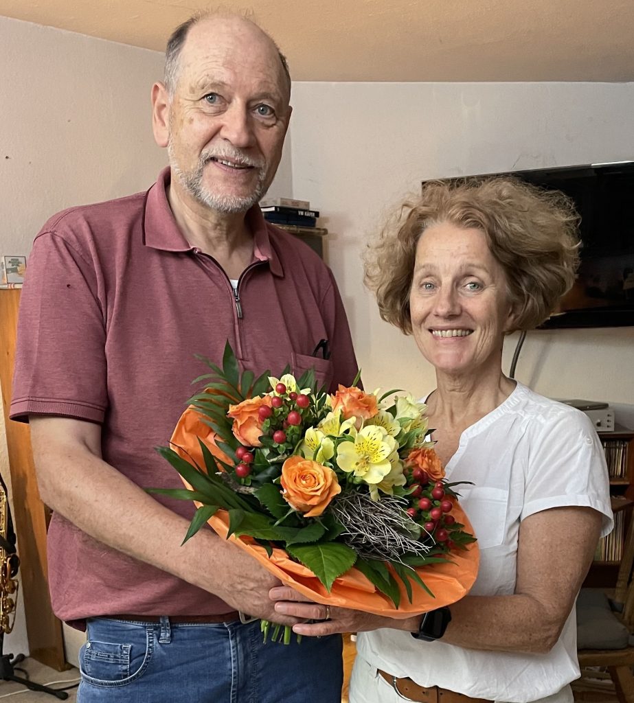 Andreas Rose überreicht Anette Wiborg einen Strauß Blumen zum 30-jährigen Dirigat.